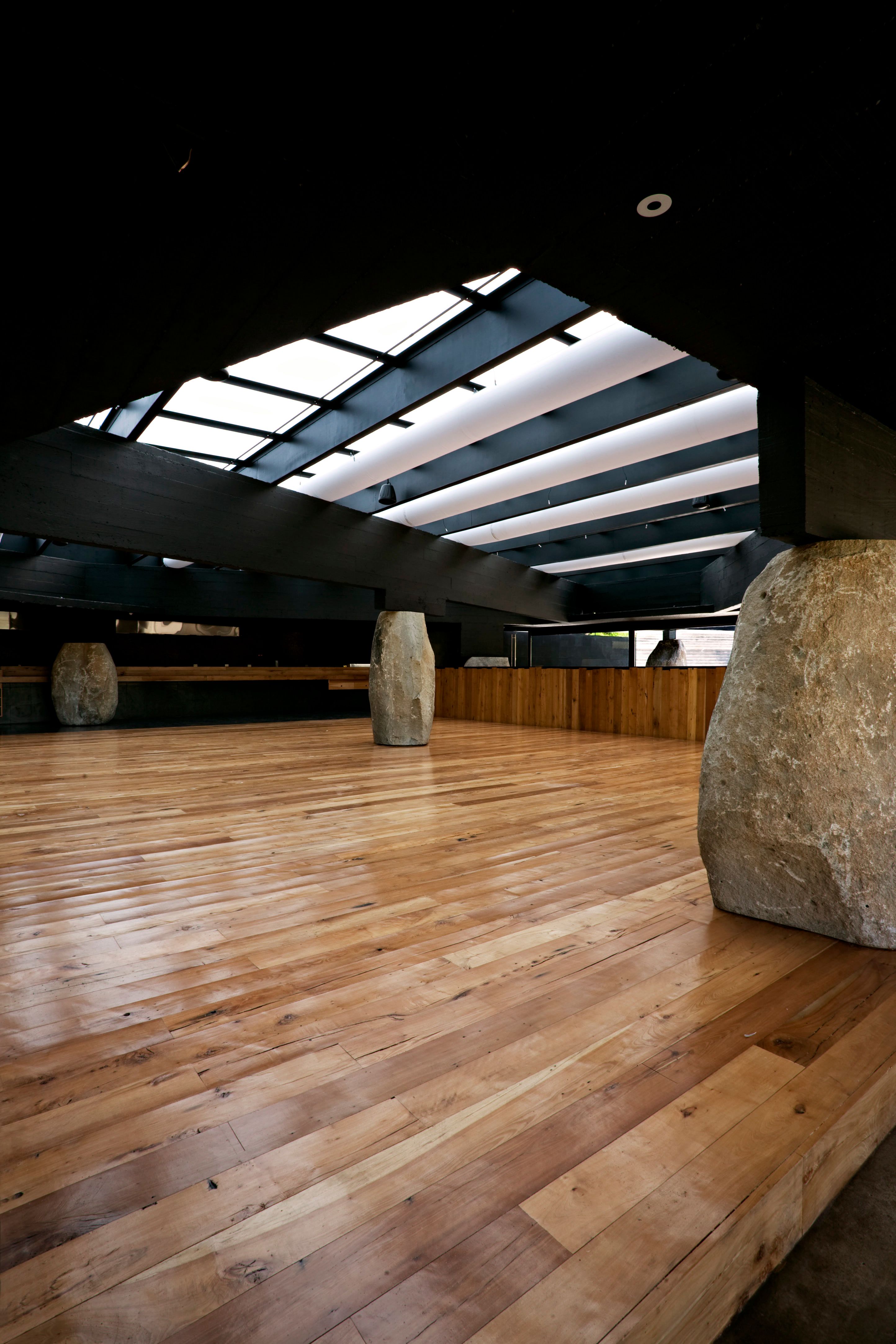The dining room under the skylights: native timber floor and boulders as columns.